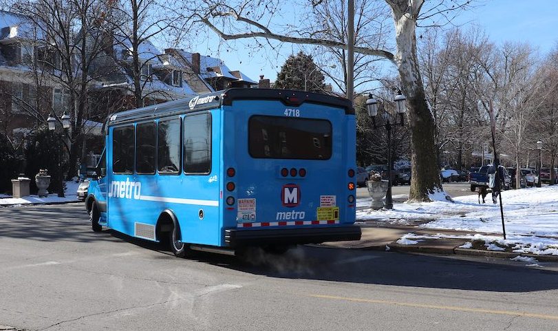 A Call‑A‑Ride van makes a right-hand turn at an intersection in a residential area.